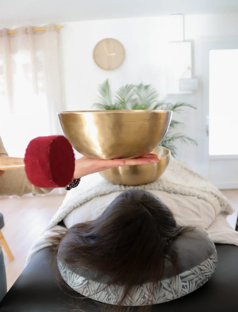plan d'un bol tibétain devant une cliente sur la table de massage pour un soin sonore